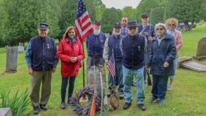 en. Bartolotta poses with members of the Sons of Union Veterans of the Civil War at a grave stone.