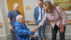 Sen. Bartolotta shakes the hand of a wheelchair-bound resident of Peters Township Post Acute facility.