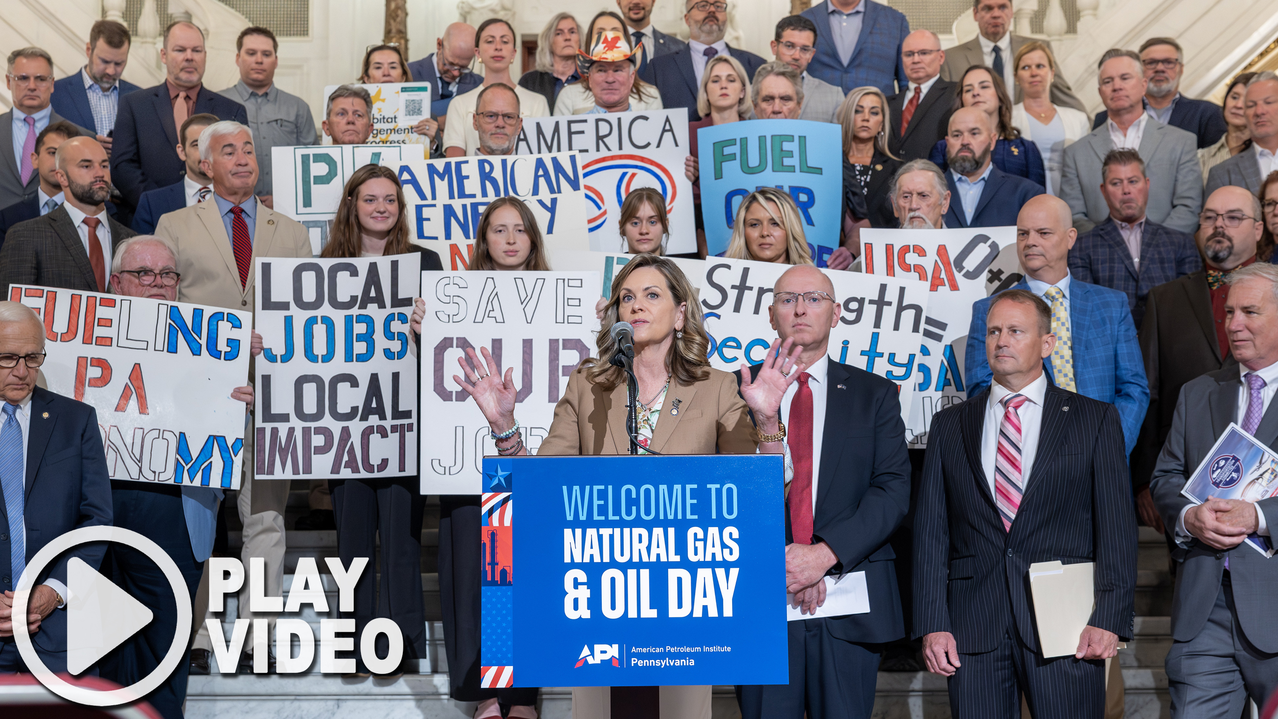 Sen. Bartolotta stands at a podium speaking in front of a big group of people holding signs in favor of expanding the gas and oil industry.