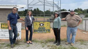 Sen. Bartolotta poses with Jared Kramer, Daisy Spearing, and Frank Swoager at the fenceline along the baseball field.