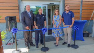 Sen. Bartolotta poses with a group of people before cutting a ceremonial ribbon.