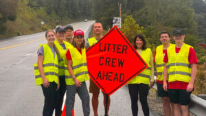 Sen. Bartolotta poses with a group of people holding a “Litter Crew Ahead” road sign.